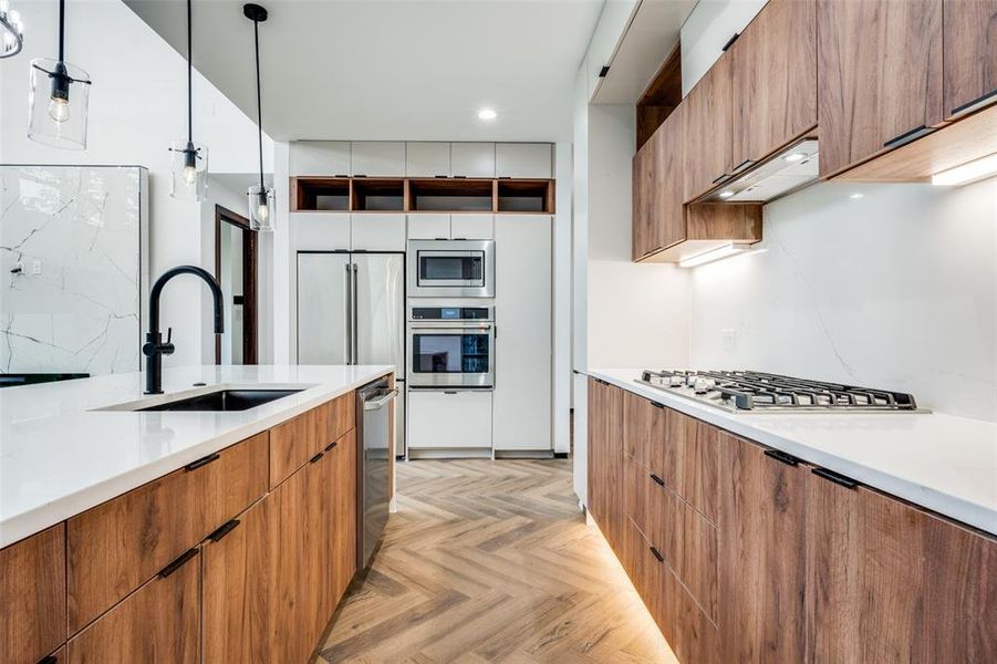 Kitchen featuring appliances with stainless steel finishes, modern cabinets, light countertops, and recessed lighting Kitchen featuring appliances with stainless steel finishes, modern cabinets, light countertops, and recessed lighting
