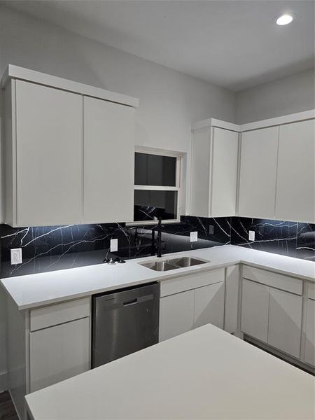 Kitchen featuring sink, white cabinetry, and dishwashing machine