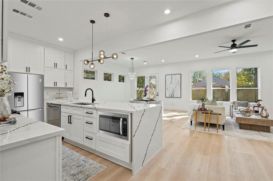 Kitchen with white cabinetry, light stone countertops, healthy amount of natural light, stainless steel appliances, and recessed lighting