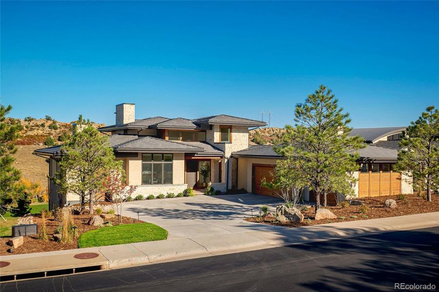 An architectural statement from first glance, the façade interplays smooth stucco planes with stone accents and linear rooflines for a composition both modern and timeless.