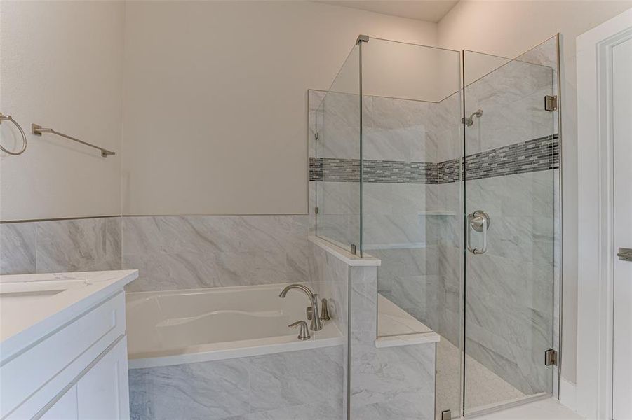 Bathroom featuring vanity and independent shower and bath