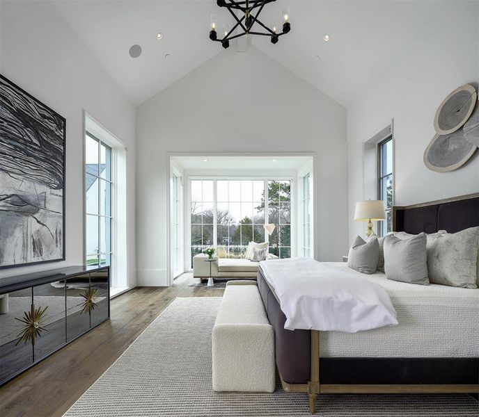 Primary bedroom with large seating area overlooking backyard