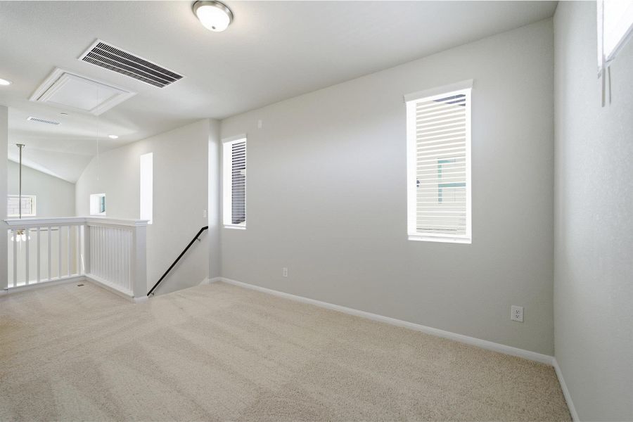Spare room with light colored carpet and lofted ceiling