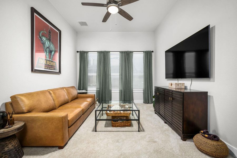 Relax in this comfortable living space, featuring well-lit interiors and a refreshing ceiling fan.