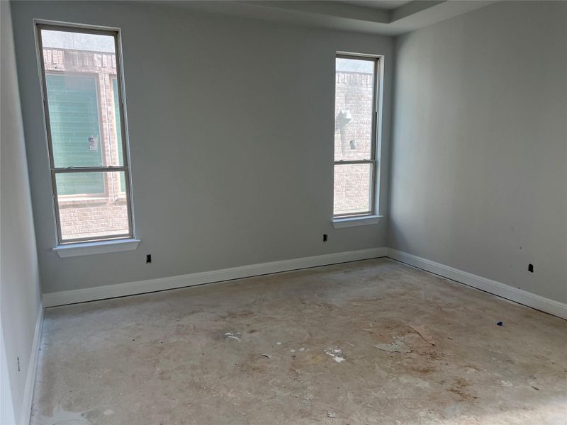 Spare room featuring baseboards and concrete floors
