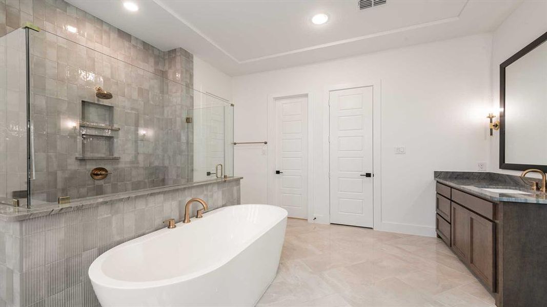 Bathroom featuring a freestanding tub, vanity, recessed lighting, a tile shower, and marble finish floors