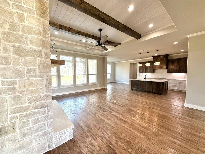 Unfurnished living room with recessed lighting, dark wood finished floors, a ceiling fan, and a wooden ceiling with exposed beams Unfurnished living room with recessed lighting, dark wood finished floors, a ceiling fan, and a wooden ceiling with exposed beams