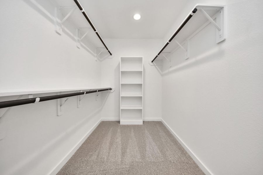 Walk-in closet that epitomizes luxury and practicality. This generously sized space features built-in shelving, offering abundant room for impeccable organization. High ceilings and recessed lighting create a bright and welcoming ambiance. Sample photo of completed home with similar floor plan. Actual colors and selections may vary. Walk-in closet that epitomizes luxury and practicality. This generously sized space features built-in shelving, offering abundant room for impeccable organization. High ceilings and recessed lighting create a bright and welcoming ambiance. Sample photo of completed home with similar floor plan. Actual colors and selections may vary.