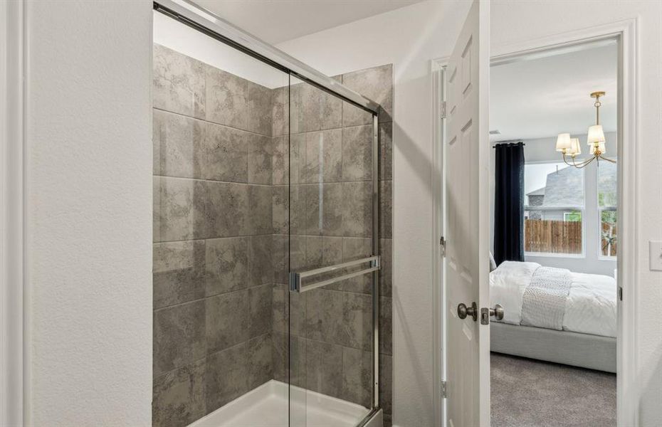 Modern owner's bath with dual vanities and a spacious shower *Model representation