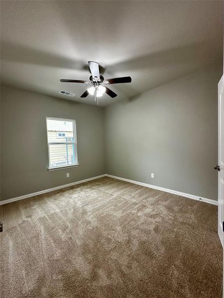 Carpeted empty room with ceiling fan