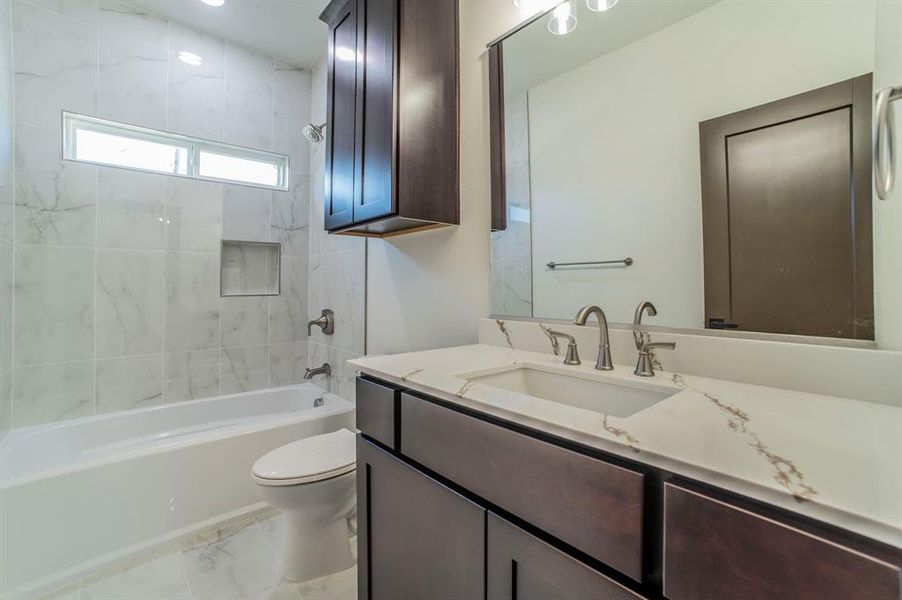 Bathroom with shower / bathtub combination, vanity, and light marble finish flooring Bathroom with shower / bathtub combination, vanity, and light marble finish flooring