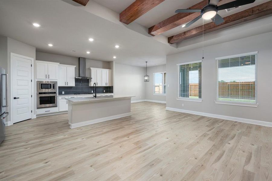 The living area boasts expansive windows that flood the space with natural light. With its open layout, the room offers seamless transitions between living, dining, and entertaining areas, creating a versatile and inviting space.