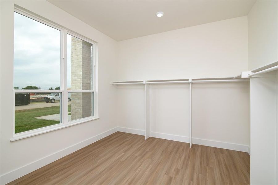 Master Closet Spacious closet featuring light hardwood / wood-style floors