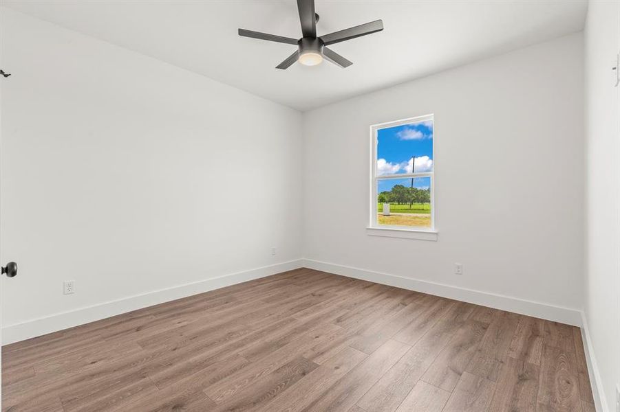 Empty room with wood finished floors and a ceiling fan