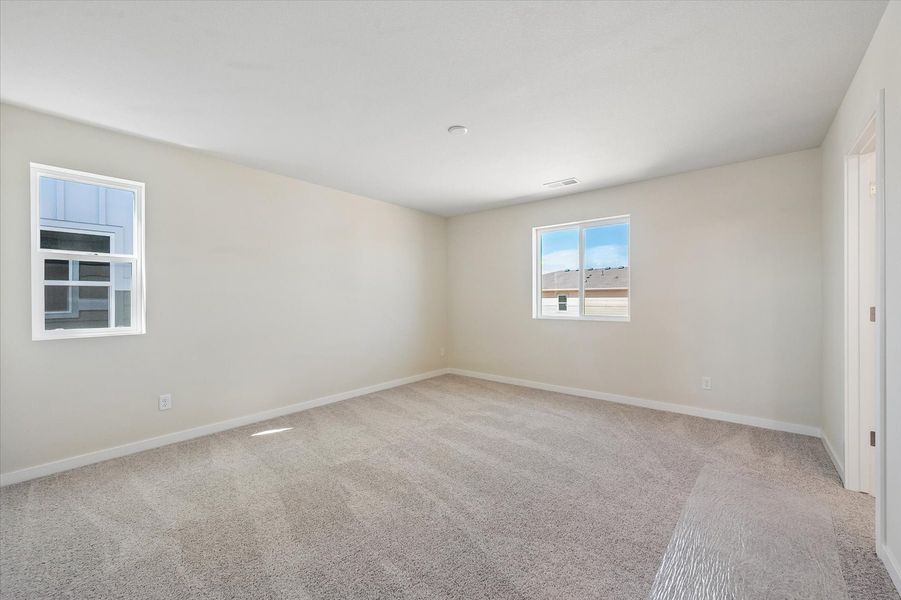 A room with a carpet and windows.