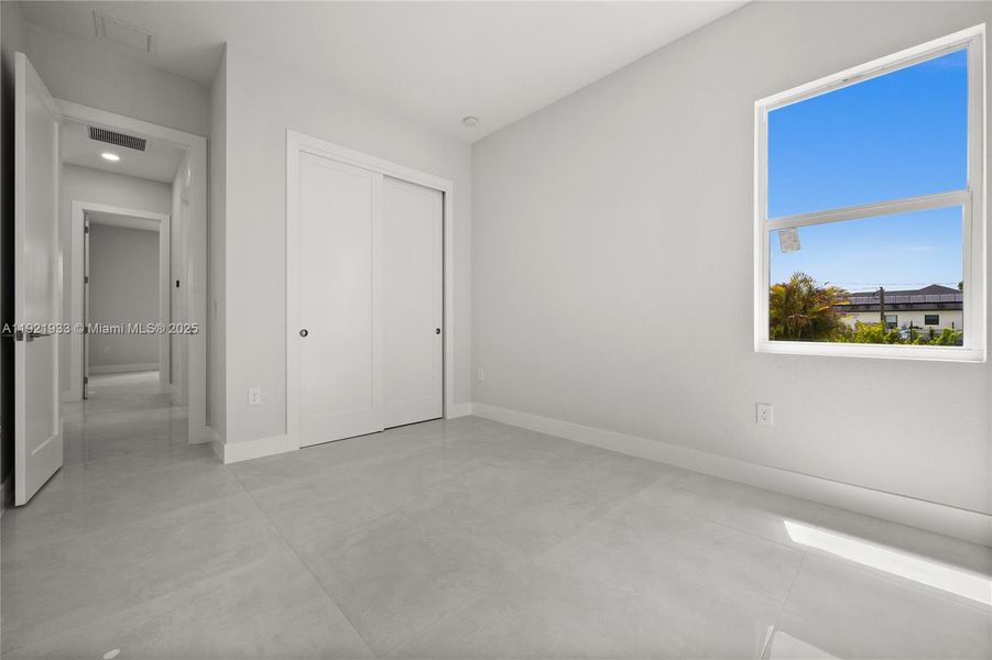 Unfurnished bedroom featuring concreteflooring and a closet Unfurnished bedroom featuring concreteflooring and a closet