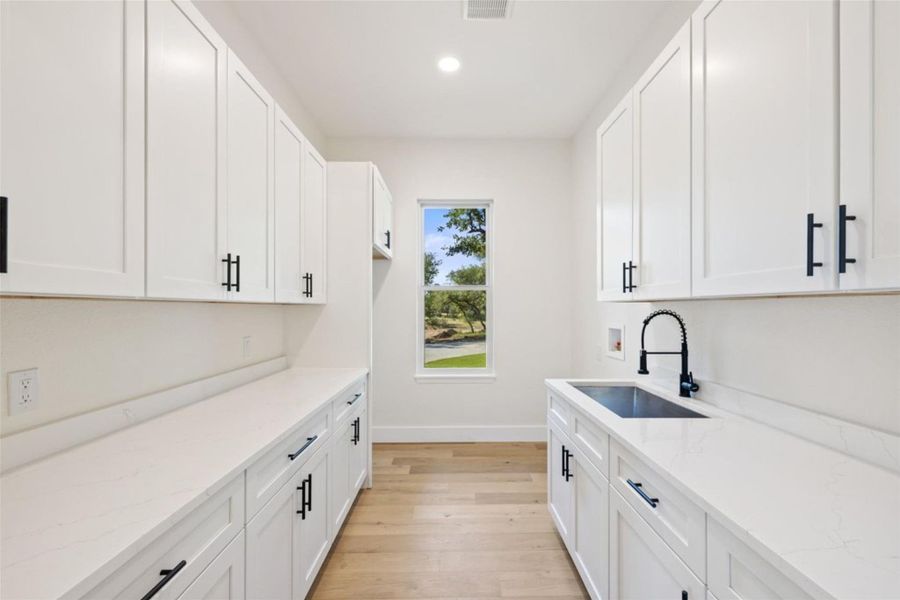 Ample storage and a deep utility sink make this well-appointed laundry room highly functional. Ample storage and a deep utility sink make this well-appointed laundry room highly functional.