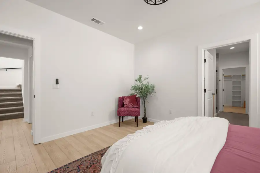 Bedroom with recessed lighting, wood finished floors, and a walk in closet