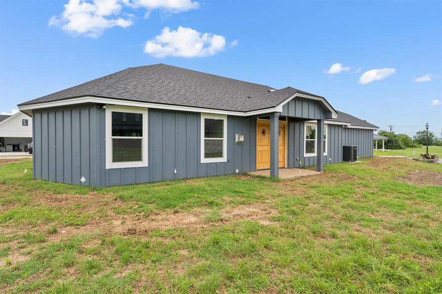View of front of house featuring board and batten siding and a front lawn