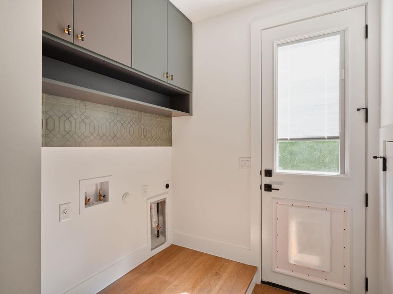 Laundry room with light wood-style floors, washer hookup, electric dryer hookup, cabinet space, and gas dryer hookup Laundry room with light wood-style floors, washer hookup, electric dryer hookup, cabinet space, and gas dryer hookup