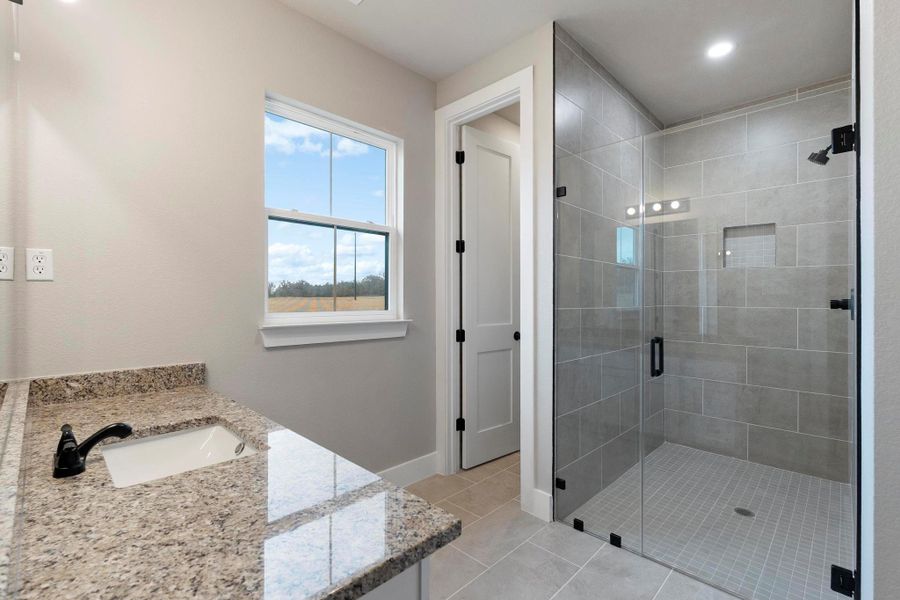 Bathroom with vanity, a shower stall, light tile patterned flooring, and recessed lighting