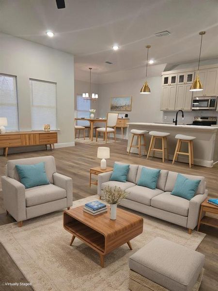 Living room featuring a notable chandelier, wood-type flooring, and sink