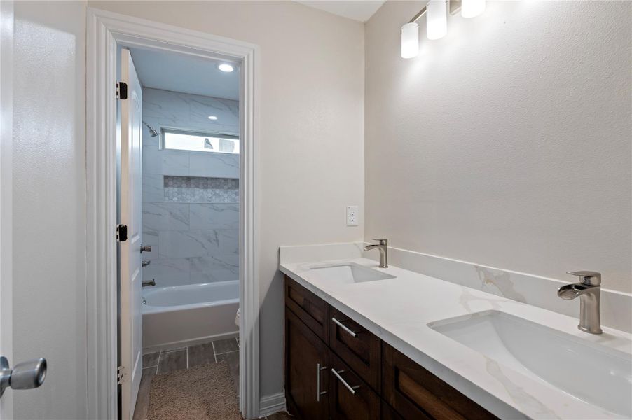 Secondary restroom with double sinks and private shower.