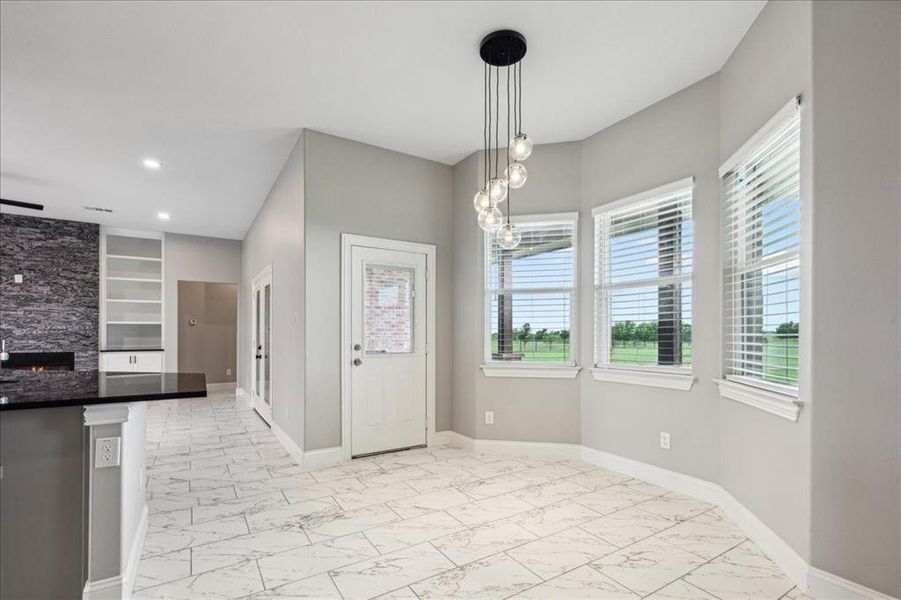 Unfurnished dining area with built in shelves and light tile floors