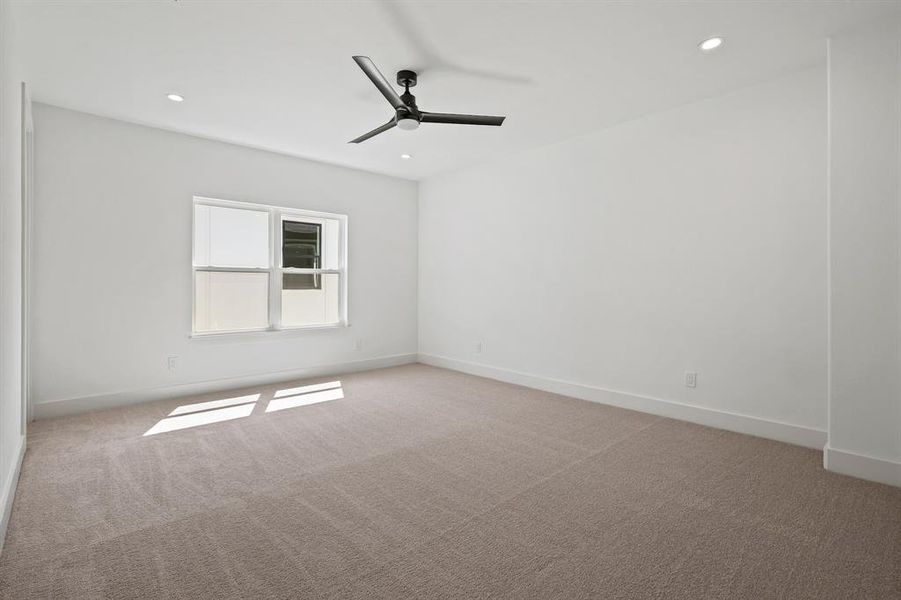 Carpeted spare room featuring ceiling fan