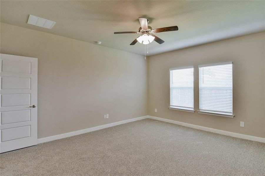 Carpeted empty room featuring a ceiling fan and baseboards Carpeted empty room featuring a ceiling fan and baseboards