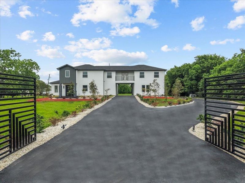 Gated entrance with extended driveway and impressive curb appeal.
