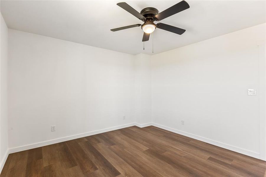 Room featuring wood-finish flooring, white baseboards, and a ceiling fan with integrated lighting