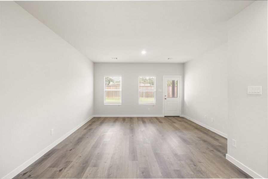 A room with a wood floor and white walls.