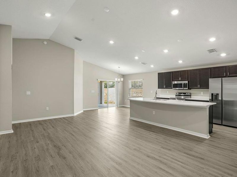 Enjoy a sunny, open-concept living area with volume ceilings and LVP flooring. Enjoy a sunny, open-concept living area with volume ceilings and LVP flooring.