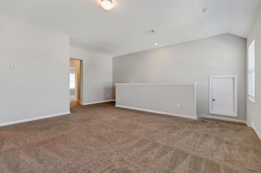 Carpeted spare room featuring lofted ceiling and baseboards Carpeted spare room featuring lofted ceiling and baseboards