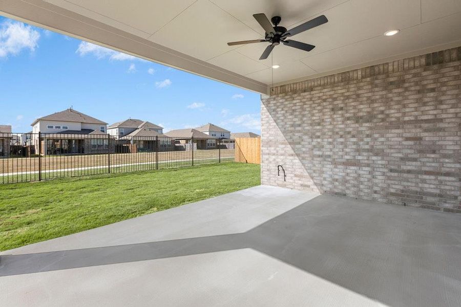 Fenced backyard with a patio, a ceiling fan, and a residential view