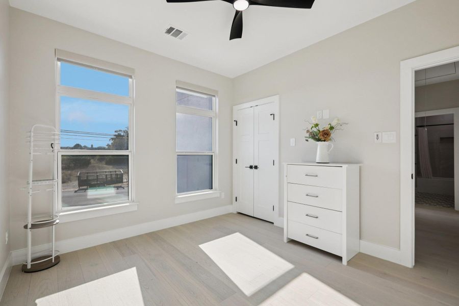 Unfurnished bedroom featuring light wood-type flooring, ceiling fan, and a closet