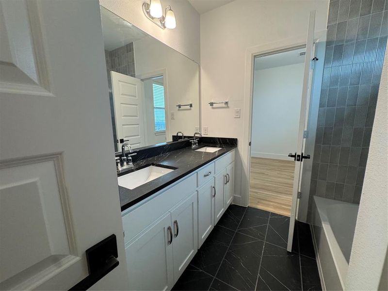 Full bathroom with double vanity, marble finish floor, and a sink