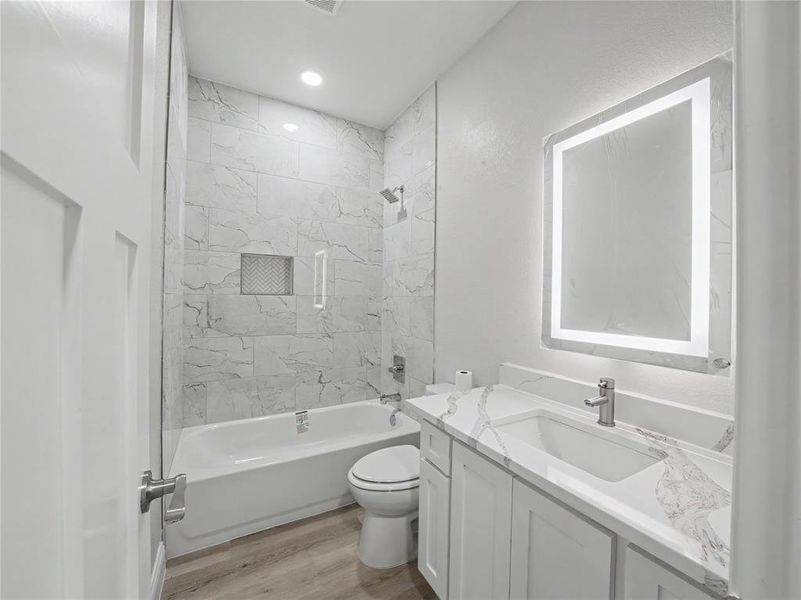 Bathroom vanity with a rectangular undermount sink, a white countertop with gray veining, and an illuminated mirror