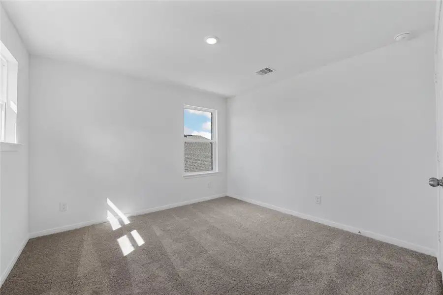 This secondary bedroom offers comfort and style with plush carpeting, neutral paint tones, recessed lighting, large window, and a generously sized closet. This secondary bedroom offers comfort and style with plush carpeting, neutral paint tones, recessed lighting, large window, and a generously sized closet.