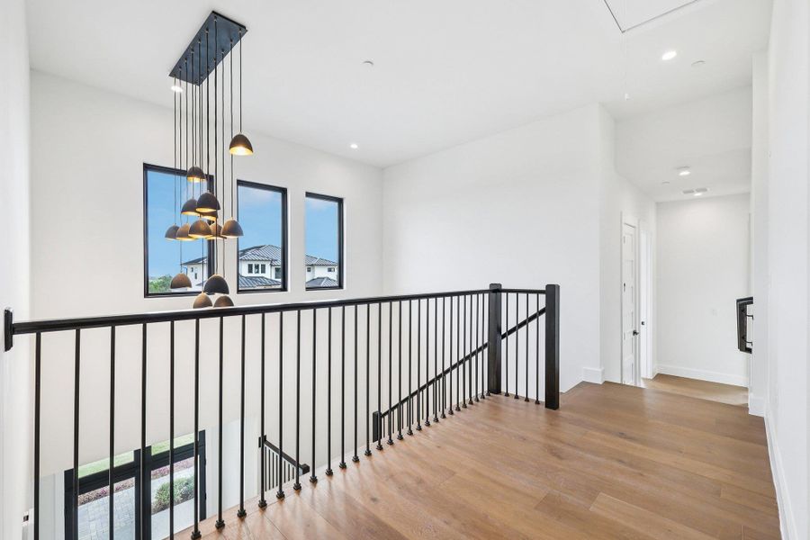 Hallway featuring an upstairs landing, light wood-type flooring, recessed lighting, and attic access