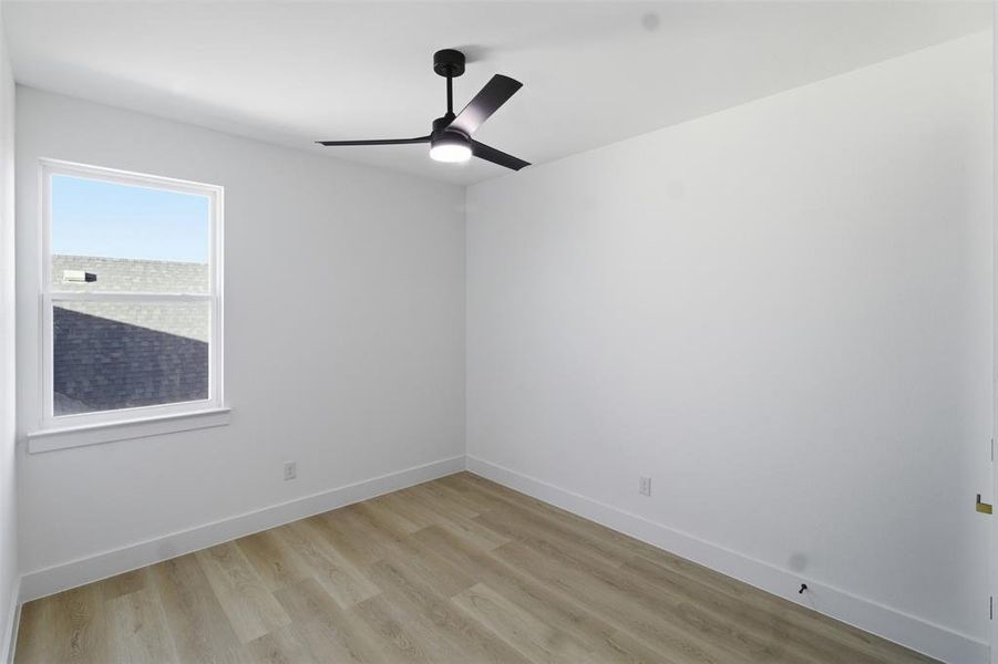 Empty room featuring light wood-type flooring and ceiling fan