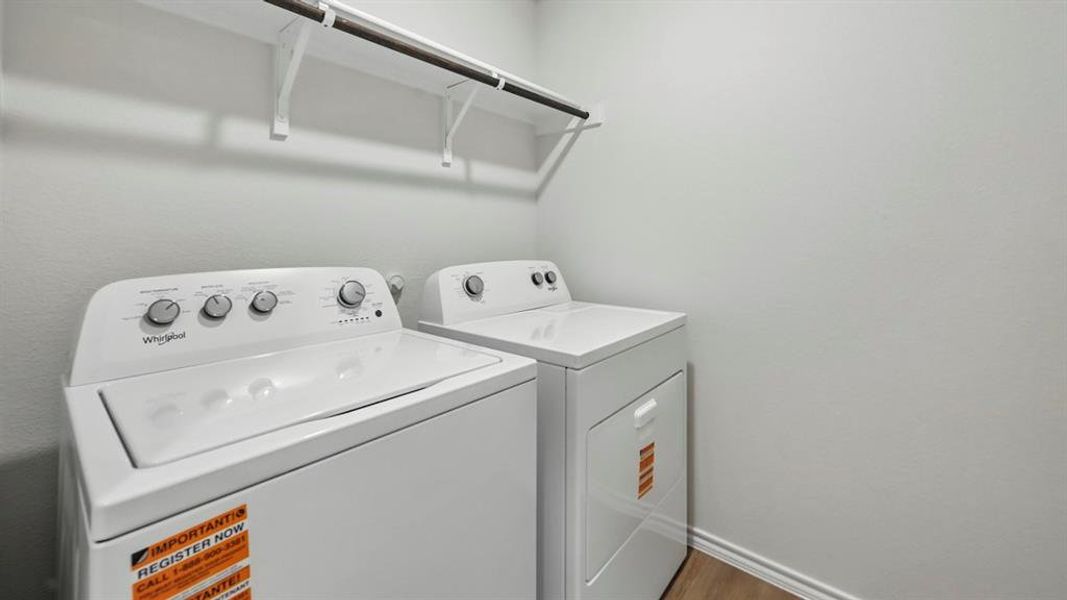 Dedicated laundry space featuring a white top-load washing machine and white electric dryer