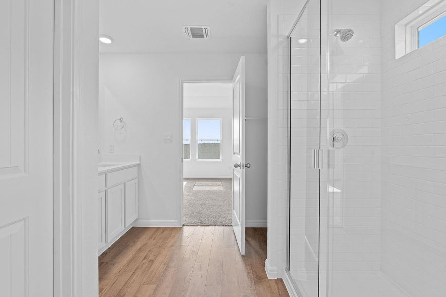 Full bathroom with vanity, light wood-type flooring, and a stall shower Full bathroom with vanity, light wood-type flooring, and a stall shower