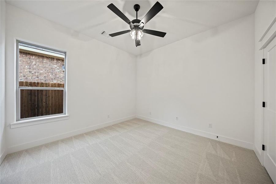 Unfurnished room featuring light colored carpet and a ceiling fan