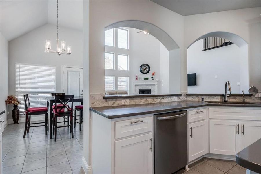 Kitchen with white cabinets, a healthy amount of sunlight, stainless steel dishwasher, and sink