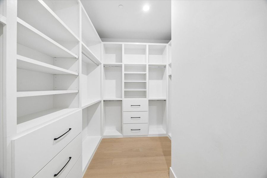 The vast walk-in has a multitude of storage built-ins and metal rods in the hang spaces.