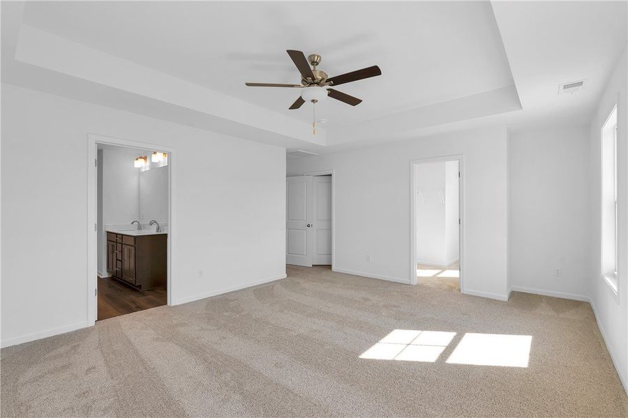 This primary bedroom features plush carpeting and