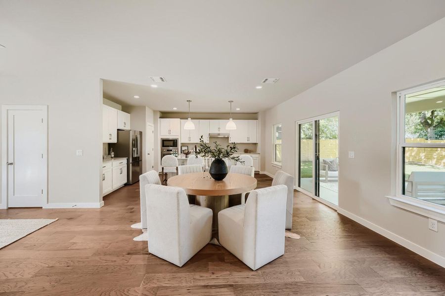 An open concept design seamlessly connects the dining area with a modern kitchen and views of the garden. An open concept design seamlessly connects the dining area with a modern kitchen and views of the garden.