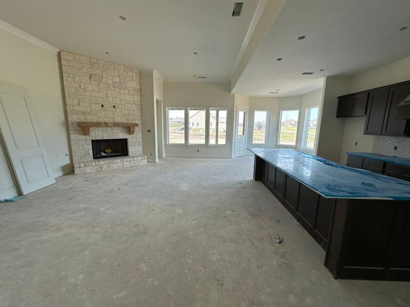 Spacious interior featuring a stone fireplace with a wood mantle, dark cabinetry, and multiple windows